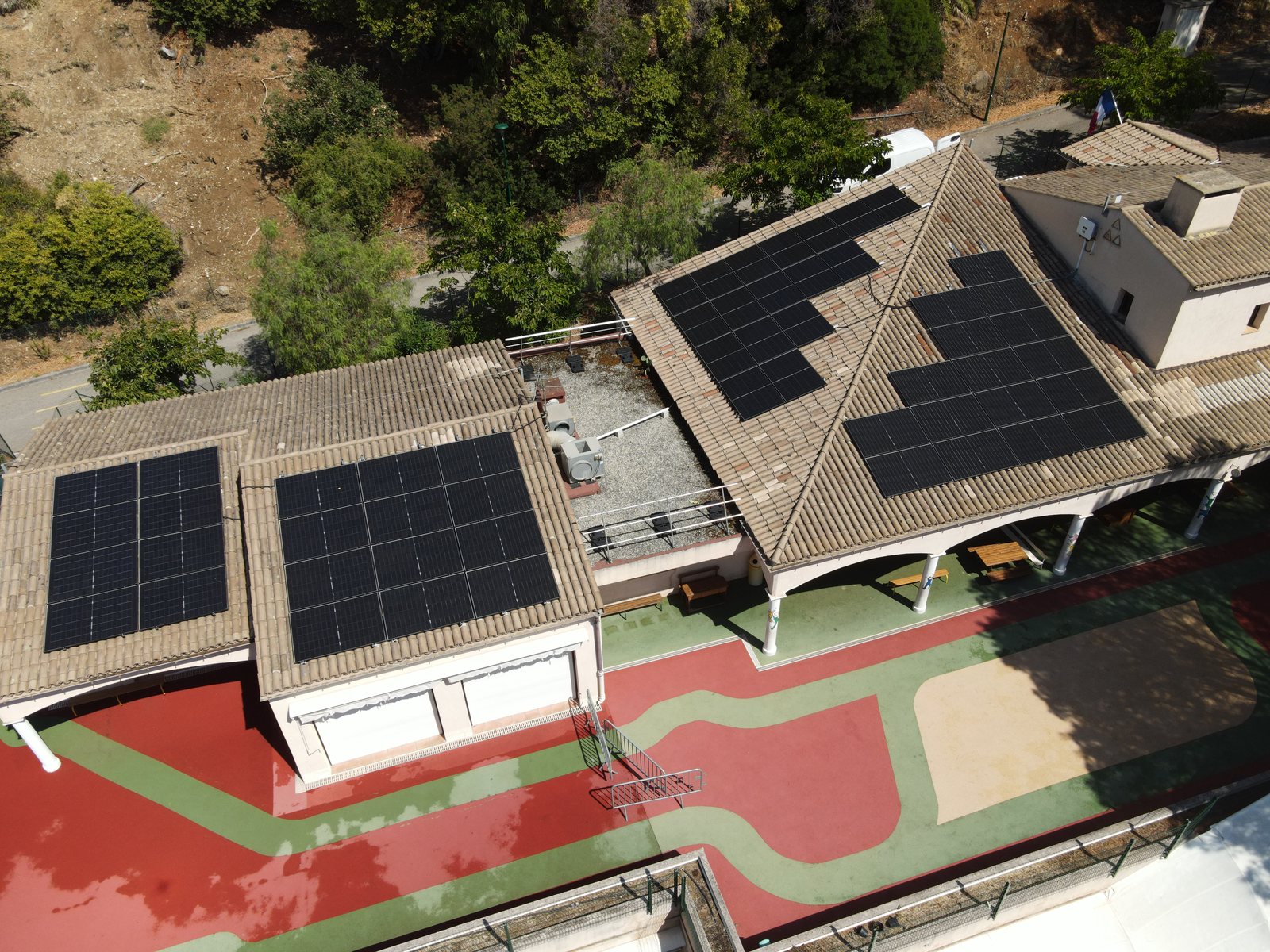 Centrale photovoltaïque sur les toitures en tuiles de l'école maternelle des Hauts de Vaugrenier à Villeneuve-Loubet, vue de drone